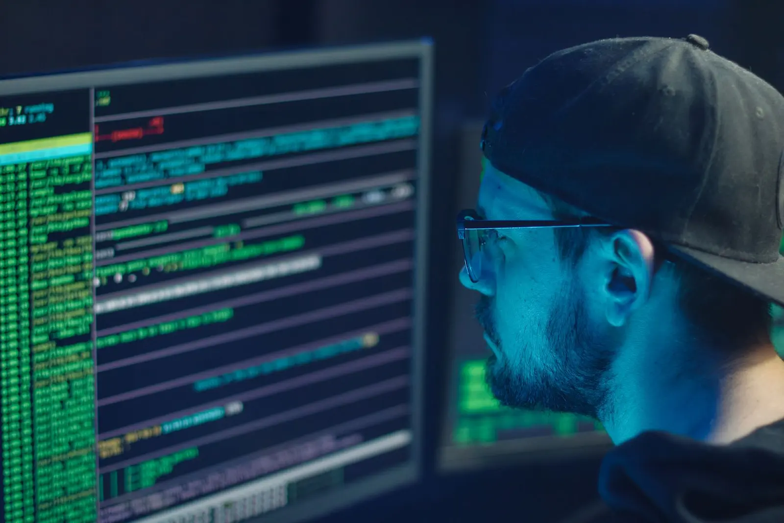 Security analyst reviewing technical information on multiple monitors